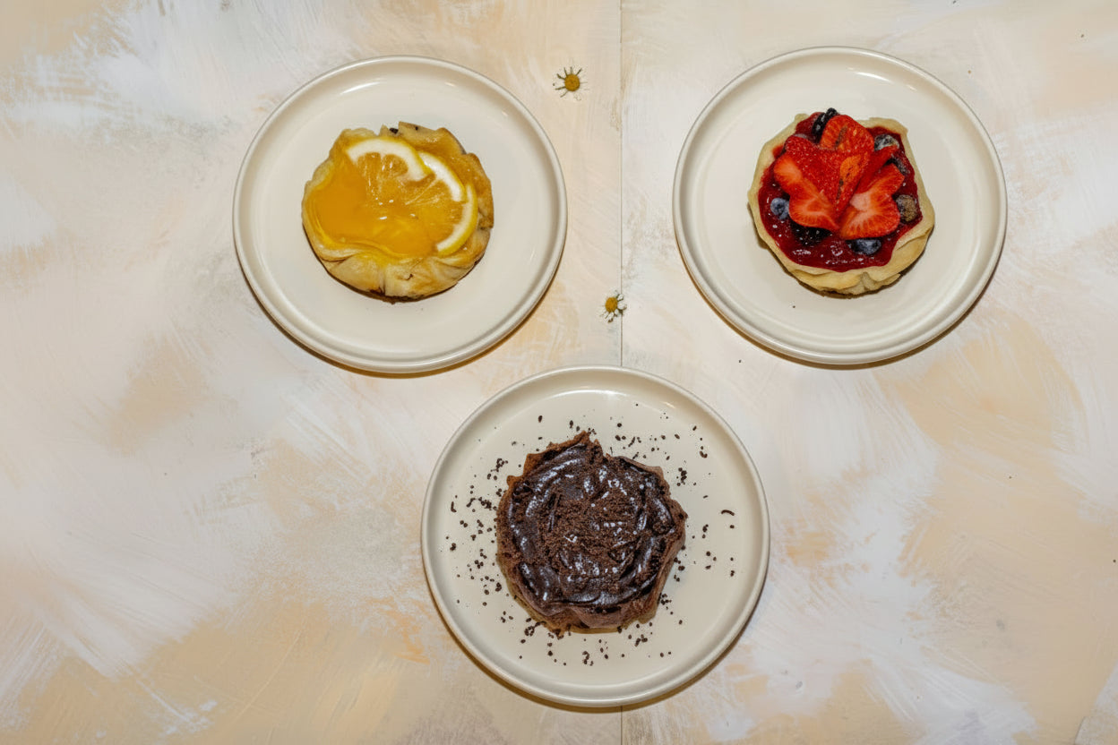 Assorted pastries and a cup of coffee on a textured surface with a checkered cloth.